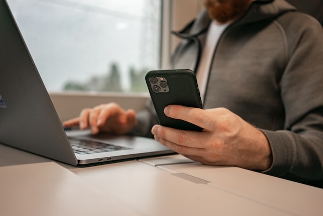 Man playing online slots on laptop and smartphone